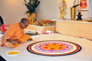 Puja mit Swami Nivedananda mit Mandala aus farbigen Pulvern