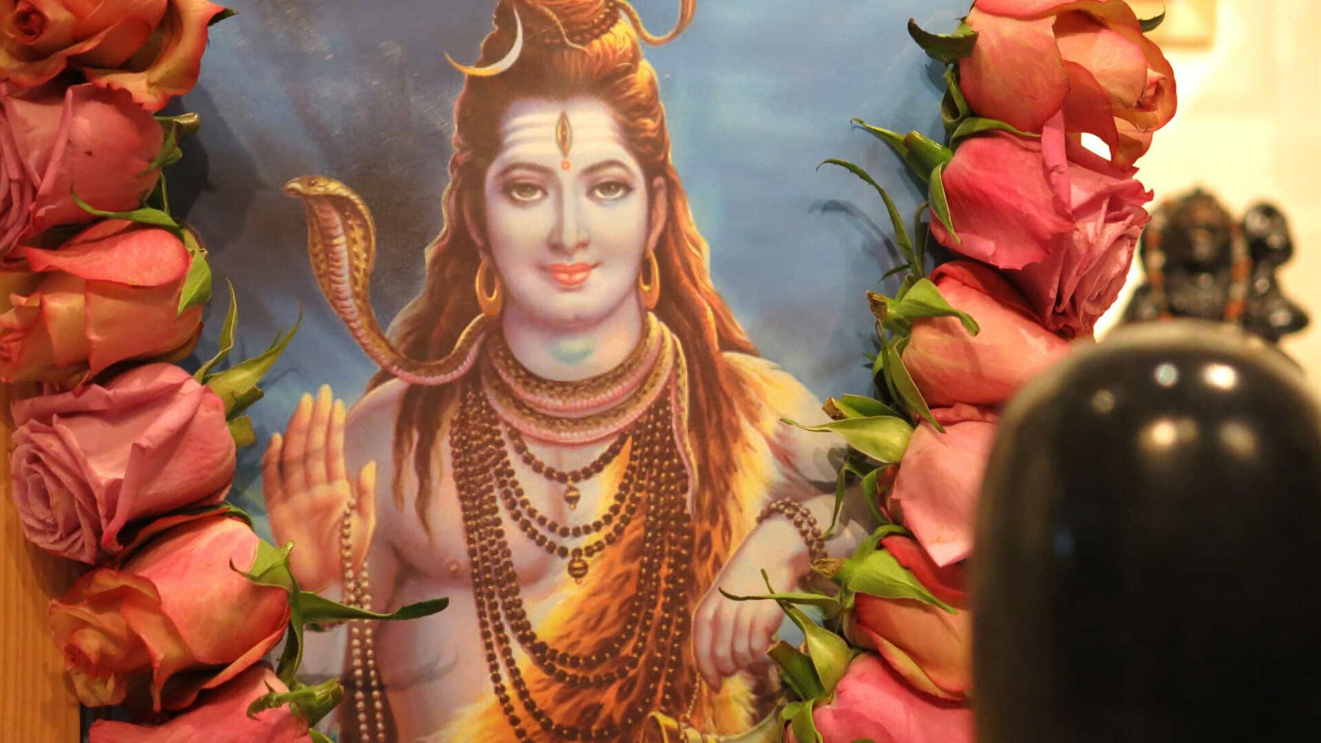 Altar an Shivaratri mit Blüten, Murtis und einem Bildnis von Shiva