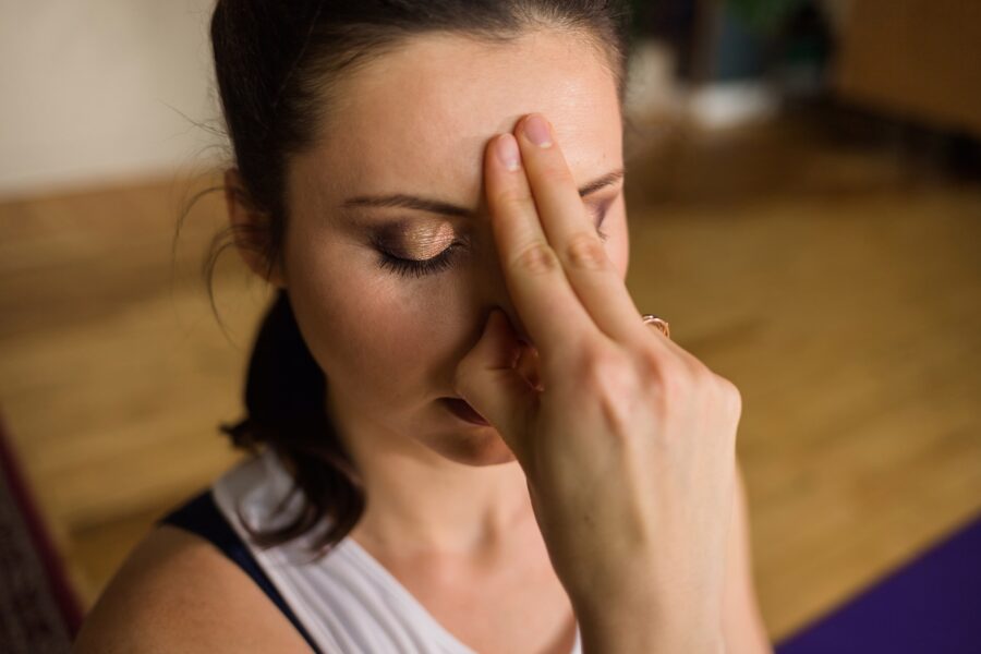 Frau bei einer Pranayama-Atemübung als Symbol für Yogatherapie, innere Ruhe und Regulation des Nervensystems