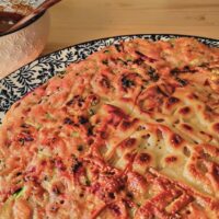Fertiger koreanischer Gemüsepfannkuchen (Yachaejeon) auf blau-weißem Teller