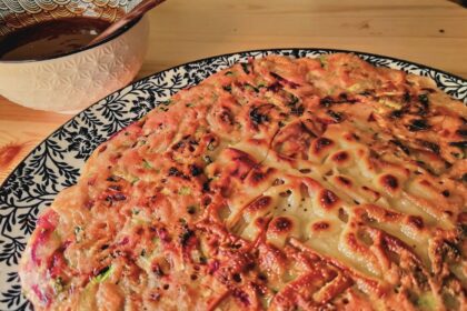 Fertiger koreanischer Gemüsepfannkuchen (Yachaejeon) auf blau-weißem Teller