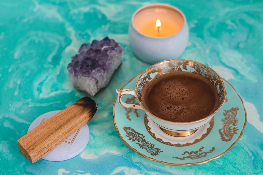 Kerze, Edelstein, Räucherwerk und Tee auf einer Oberfläche