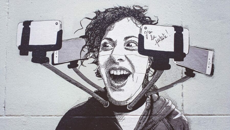 Mann mit einer Kette aus Selfie Sticks filmt sich selbst von allen seiten